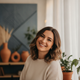 Smiling woman's headshot, conveying trust and satisfaction. The background features subtle terracotta and slate blue tones.